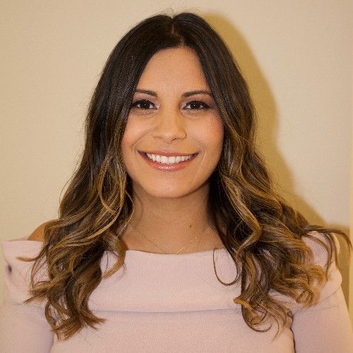 Person wearing an off-shoulder top with long, wavy hair.